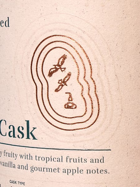 Arran Quarter Cask "The Bothy" label detail showing an outline of the Isle of Arran enclosing two eagles and a pot still