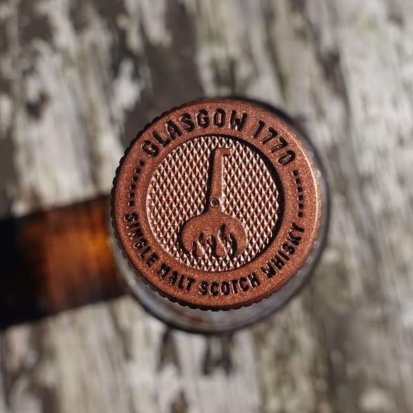 Glasgow 1770 bottle stopper showing the "fired still" logo