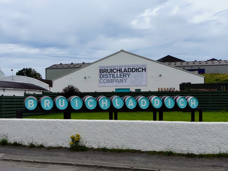 Bruichladdich's Distillery welcome sign, made out of barrels, each carrying a different letter in the name in white on turquoise background