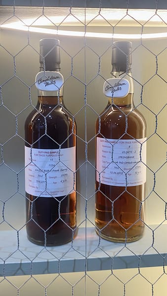 Two Springbank cage bottles, behind the famous chicken wire screen, at Springbank distillery