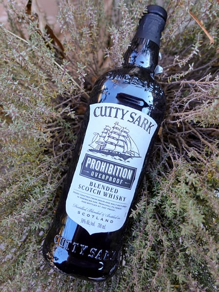 Image of the Cutty Sark Prohibition blended scotch bottle resting on vegetation