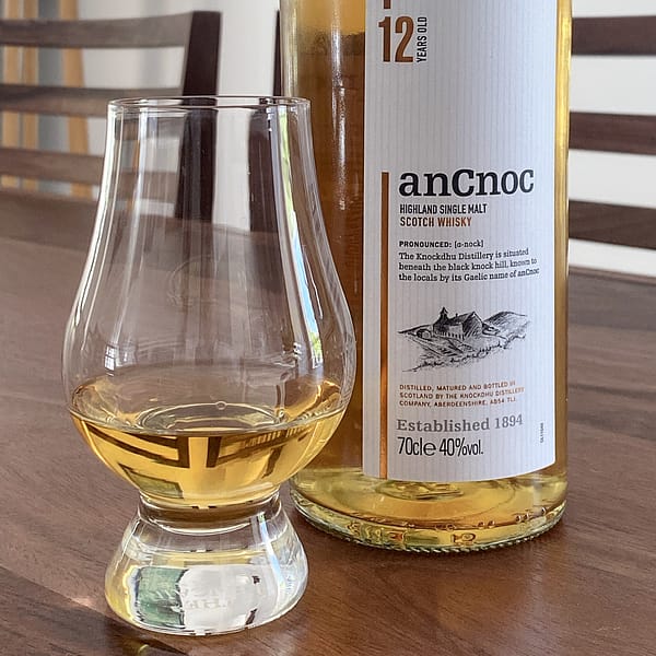 picture of an anCnoc 12-year-old bottle with Glencairn glass containing some of the same whisky