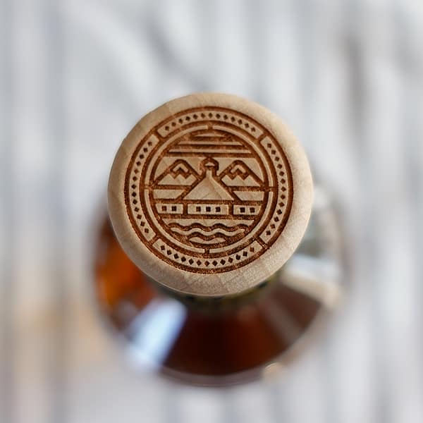 Ardnahoe's Inaugural Release wooden cap with the distillery's logo which depicts a stylised image of the distillery building framed by the sea and hills of Islay