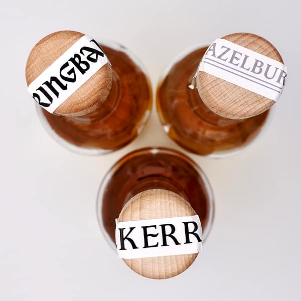 Springbank Distillery Hand filled exclusives - shot from the top to show the caps each with a band for the individual brnad bands, Hazelburn, Kilkerran and Springbank