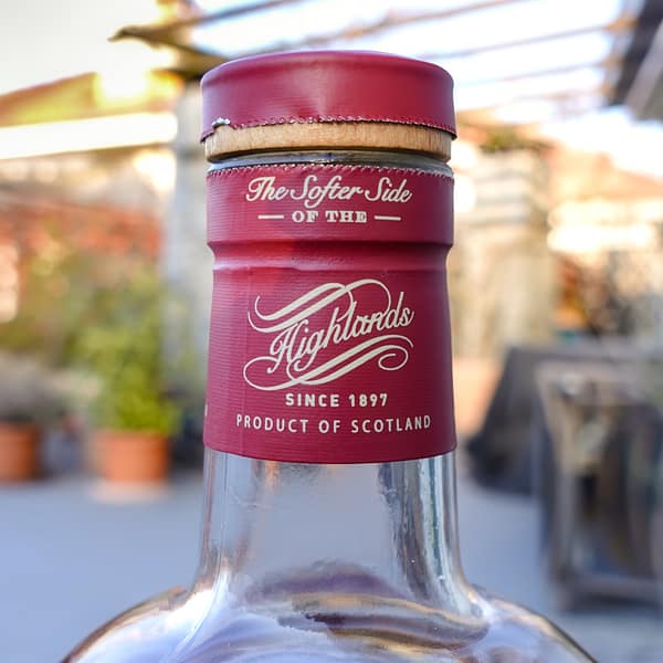 Bottle detail of the Tomatin Cask Strength single malt bottle, showing the neck seal carrying the tagline "The Softer Side of the Highlands"
