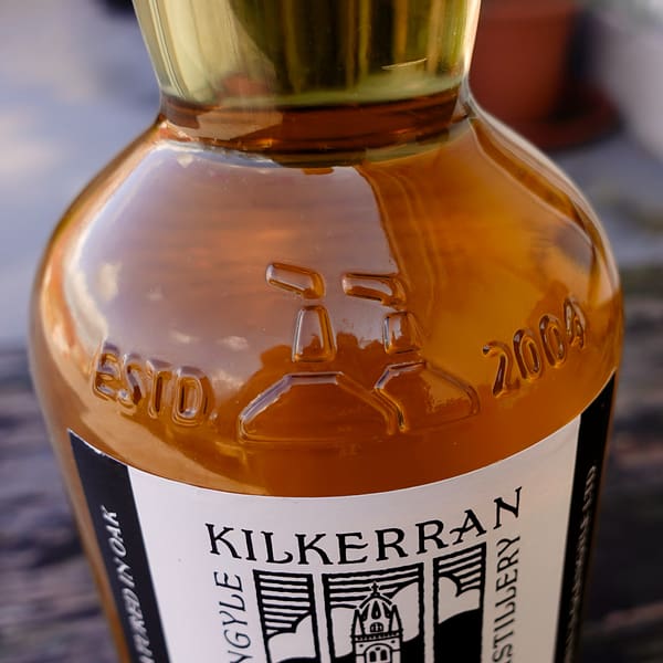Kilkerran 8-year-old Cask Strength 2022 ex-Bourbon cask, bottle detail, showing the Std. 2004 date and the outline of the distillery's two stills.