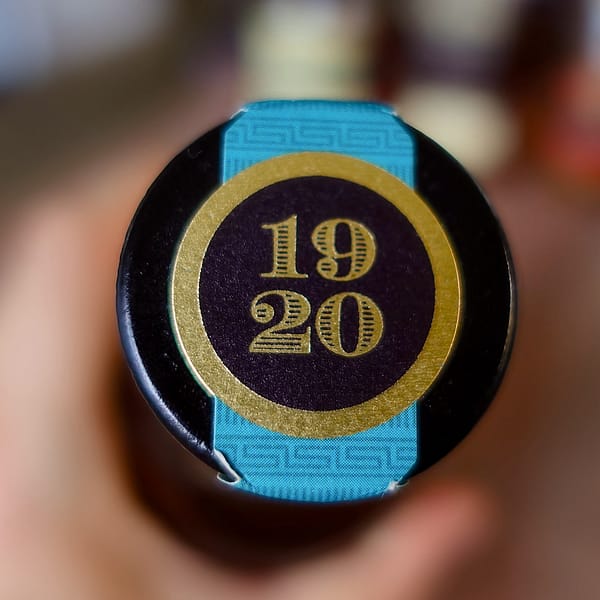 Old Forester 1920 cap seal - a teal seal band with a gold and black circle with the 1920 date in gold
