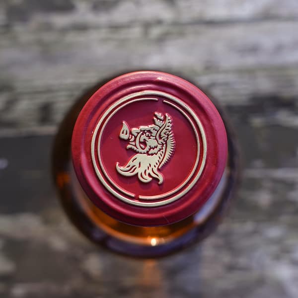 Cap detail of the Tomatin Cask Strength single malt bottle, showing the boar head heraldry symbol of the distillery