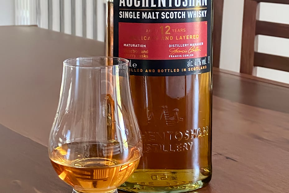 Auchentoshan 12 year old bottle next to a Glencairn glass filled with the same whisky