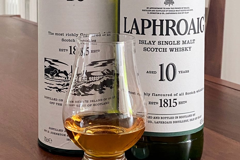 Laphroaig 10 year old bottle with tube box and Glencairn whisky glass