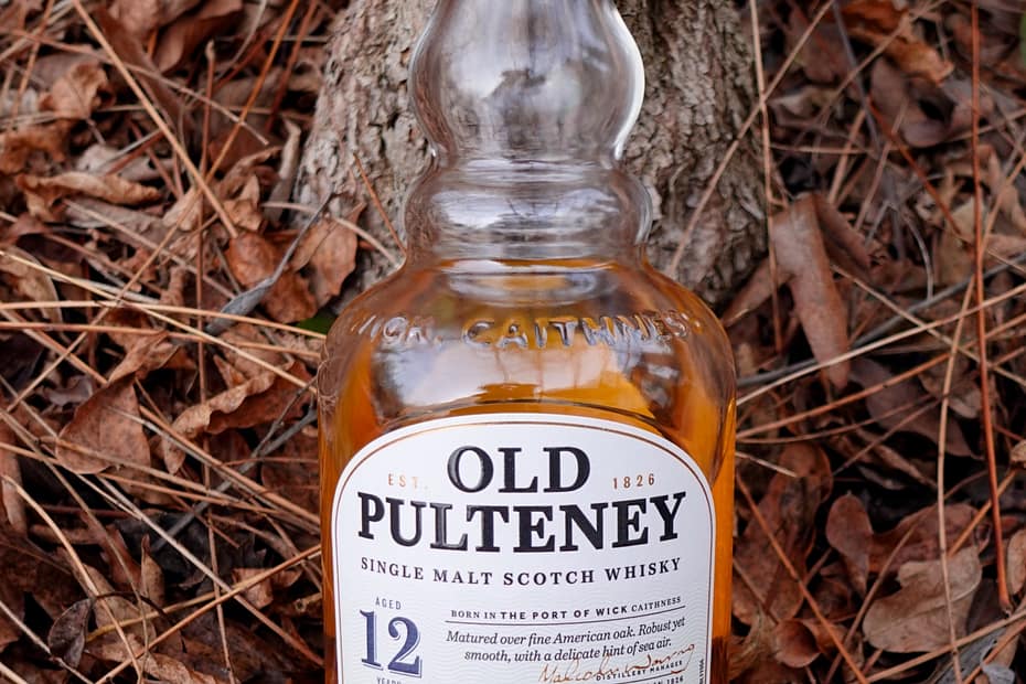 Image of the Old Pulteney 12 bottle on a backdrop of dried leaves