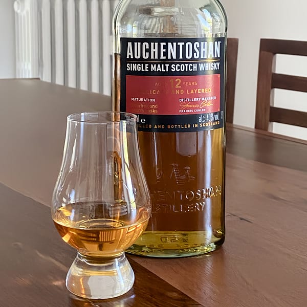 Auchentoshan 12 year old bottle next to a Glencairn glass filled with the same whisky